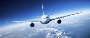 白色飛機在清澈藍天的雲層上方高飛 — 4K 飛機壁紙