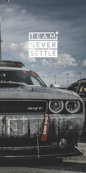 風化黑色道奇挑戰者SRT在賽車場上，帶有「TEAM NEVER SETTLE」字樣。 — 汽車 壁紙