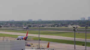 西南航空飛機在機場跑道上滑行，背景為城市天際線。 — 伸展台 壁紙