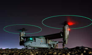 軍用傾轉旋翼機在夜間懸停，帶有發光旋翼痕跡。 — 直升機 壁紙