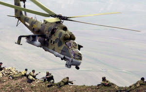 軍用直升機在俯瞰山谷的山坡上靠近士兵盤旋。 — 軍事動圖 壁紙