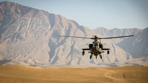 軍用直升機在沙漠上空盤旋，背景有山脈 — 阿富汗 壁紙