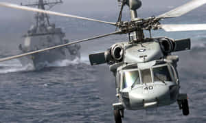 軍用直升機在海洋上空飛行，附近有軍艦。 — 直升機 壁紙