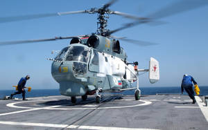 軍用直升機在航空母艦甲板上，機組人員引導它。 — 軍事動圖 壁紙