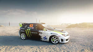 帶有Monster Energy品牌的Subaru拉力賽車，在日落時分停泊在沙灘上。 — 日落 壁紙