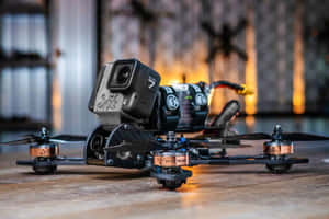黑色競速無人機配備GoPro相機，置於工業環境的木地板上 — 太空船 壁紙