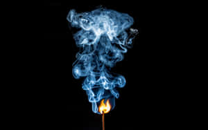 一根燃燒的火柴，藍色煙霧在黑色背景上升起。 — 省電 壁紙