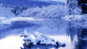 積雪河流，以冷藍色調反射冬日樹木和山脈。 — 冬季風景 壁紙
