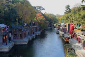 傳統中式運河，沿水邊有秋葉和彩色旗幟。 — 湖泊 壁紙