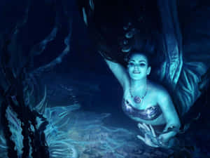 一條發光的美人魚在海洋生物旁邊的水中微笑。 — 美人魚 壁紙