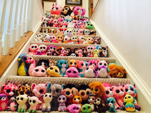 樓梯上覆蓋著排列成行的色彩繽紛毛絨玩具。 — Beanie Boos 壁紙