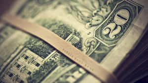 一條標有 rubber band bank 的橡皮筋束住一疊復古綠色美元鈔票。 — 金錢 壁紙