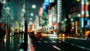 夜晚城市街道，有發光的霓虹招牌和模糊的車燈在濕漉漉的路面上。 — 城市燈光 壁紙