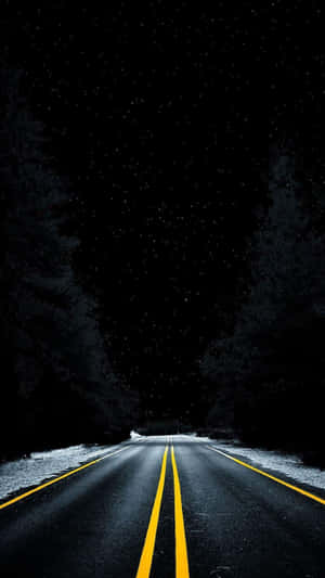 夜晚星空下蜿蜒的道路，兩側有積雪和樹木。 — 黑夜 壁紙