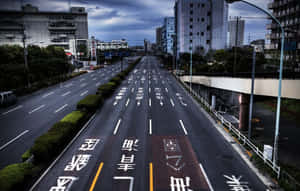 多雲天空下，帶有日本道路標記的空蕩城市高速公路。 — 日式 壁紙
