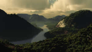 在陰天之下，一條河流流經森林覆蓋的山脈。 — 平靜 GIF 壁紙