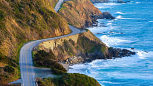 蜿蜒的海岸公路，夕陽下海浪拍打懸崖。 — 海灘 壁紙
