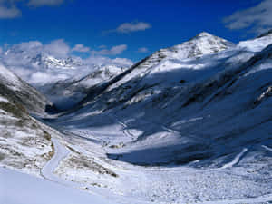 積雪的山口，蜿蜒的道路，藍天白雲 — 冬季風景 壁紙