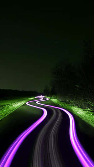 夜晚的蜿蜒道路，帶有紫色光軌和發光的綠色邊緣。 — 霓虹綠美學 壁紙