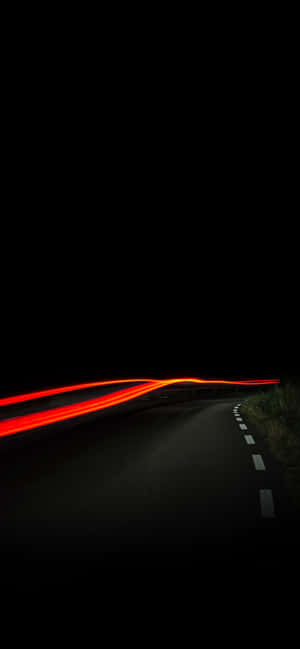 夜晚的道路，有移動汽車的紅色和橙色光條。 — Moto E13 壁紙
