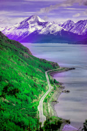 蜿蜒的道路沿著綠色山坡，旁邊是一個湖泊，在紫色天空下襯托著積雪的山峰。 — 鄉村道路 壁紙