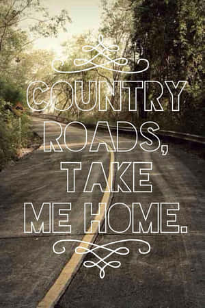 蜿蜒的鄉村道路穿過樹林，帶有country roads take me home文字。 — 鄉村道路 壁紙