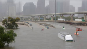 被洪水淹沒的城市高速公路，有被淹沒的車輛和水中的緊急救援人員。 — 凋零風暴 壁紙
