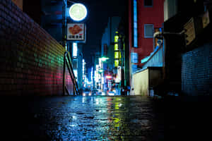 雨夜中霓虹燈閃爍的小巷，發光標誌在潮濕的路面上反射。 — MacBook Pro M3 壁紙