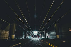 空蕩的城市隧道，有發光的黃色燈光和混凝土柱。 — 洛杉磯 壁紙
