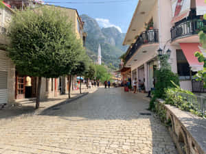鵝卵石街道，背景有建築物和山脈 — 街頭 壁紙