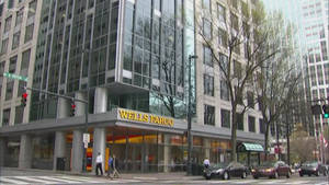 Wells Fargo 銀行大樓，有行人過馬路和汽車在十字路口。 — 城市 壁紙