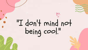 桌布上寫有引言「I don't mind not being cool」，周圍環繞著色彩繽紛的抽象形狀。 — 酷 壁紙