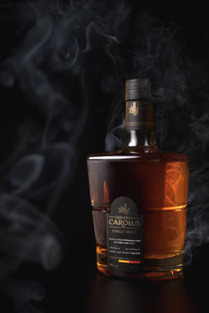 Golden Carolus 威士忌酒瓶，煙霧在黑暗表面上環繞。 — 小米平板 8 壁紙