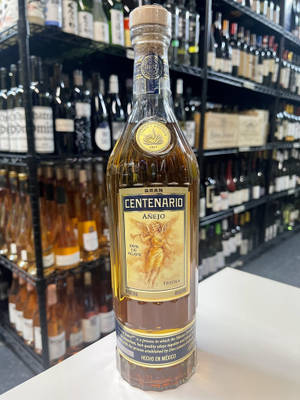 在酒舖白色櫃檯上展示的一瓶 Gran Centenario Añejo 龍舌蘭酒。 — 雜貨店 壁紙