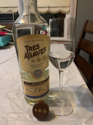 桌上有一瓶龍舌蘭酒和杯子，附近有一張椅子。 — 葡萄酒 壁紙
