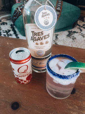 一瓶龍舌蘭酒、一罐葡萄柚蘇打水和一杯鹽味瑪格麗特在木桌上。 — 3:4 壁紙