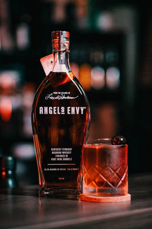 Angel's Envy波本威士忌瓶和帶櫻桃的雞尾酒在夜晚的酒吧 — 小米平板 9 Pro 壁紙