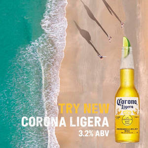 Corona Ligera啤酒瓶附萊姆在沙灘上，靠近海浪和長板玩家。 — 啤酒 壁紙