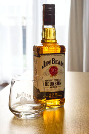 窗邊木桌上的Jim Beam波本酒瓶和酒杯。 — 小米平板 壁紙
