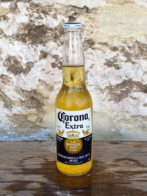 冰涼Corona Extra啤酒瓶在潮濕木上，石牆背景 — 啤酒 壁紙