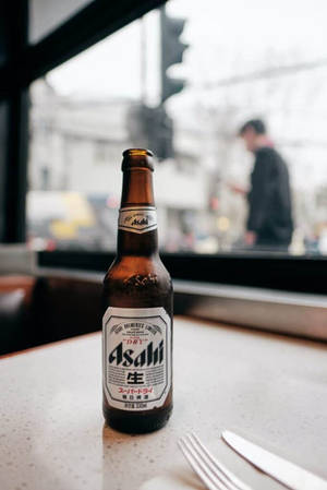 冰涼的朝日啤酒瓶放在檯面上，模糊的城市街道景觀。 — 攝影 壁紙