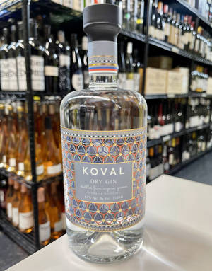 一瓶Koval Dry Gin放在商店櫃檯上，後面有酒架。 — 美國 壁紙