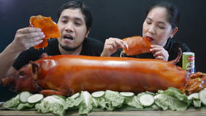 情侶享受脆皮烤豬肉配黃瓜和生菜。 — 豬 壁紙
