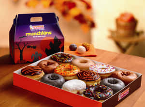 萬聖節主題的Dunkin' Donuts Munchkins甜甜圈盒，放在木桌上，有秋葉。 — Dunkin Donuts 壁紙