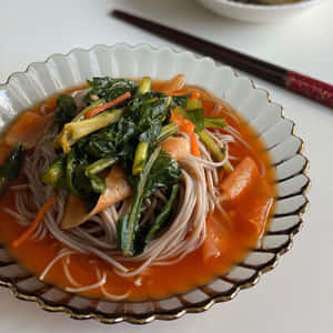 裝飾碗中的菠菜胡蘿蔔蕎麥麵，旁邊有筷子。 — 4K 食物 壁紙