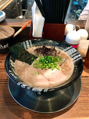 一碗熱騰騰的拉麵，有豬肉、青蔥和海苔，放在木桌上。 — 壽司 壁紙