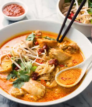 一碗熱騰騰的辣雞肉咖哩麵，配以豆芽和香菜。 — Motorola Razr Ultra 2026 壁紙