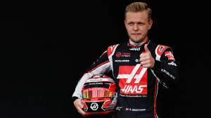 F1車手凱文·馬格努森身穿哈斯制服手持頭盔豎起大拇指。 — 中性 壁紙