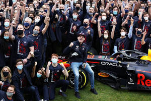 F1車隊和車手在草地上舉起拳頭慶祝錦標賽勝利。