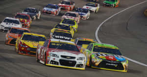 NASCAR賽車在明亮的燈光下夜間在賽道上高速飛馳。 — 汽車 壁紙
